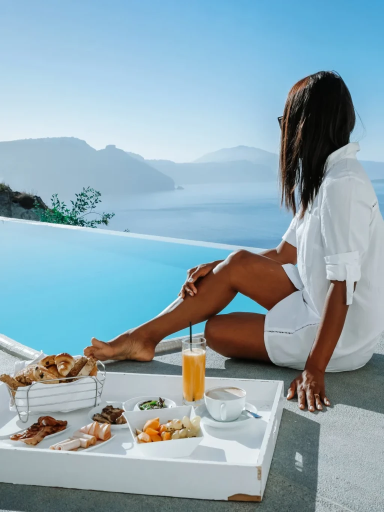 luxury travel services, woman at pool in santorini
